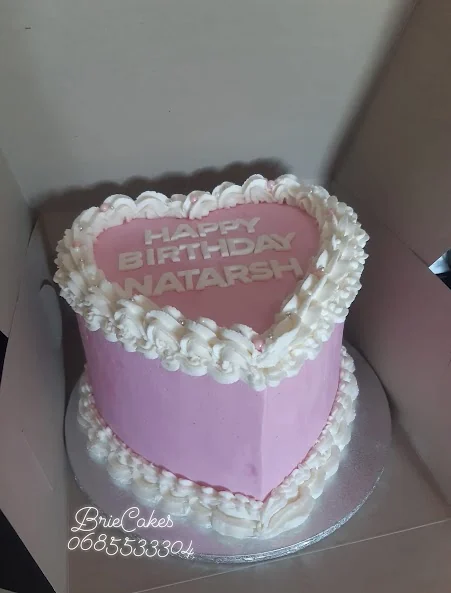 Tall pink heart birthday cake with white piping by Brie Cakes